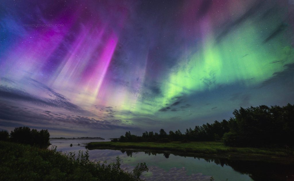 Great aurora corona above misty water